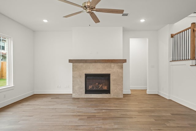 unfurnished living room featuring visible vents, baseboards, ceiling fan, and wood finished floors