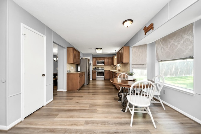 dining area with baseboards and light wood-style floors