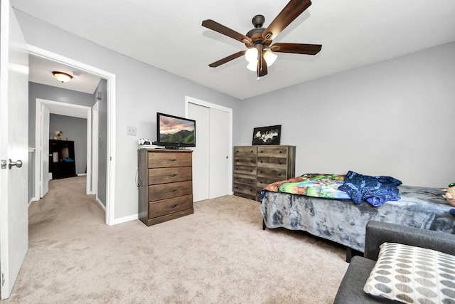 carpeted bedroom featuring ceiling fan, baseboards, and a closet