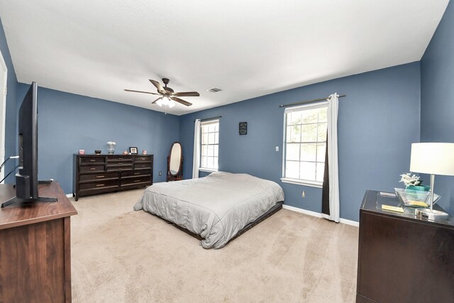 bedroom featuring ceiling fan, baseboards, multiple windows, and carpet