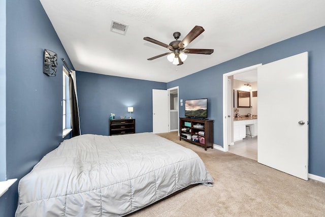 carpeted bedroom with connected bathroom, ceiling fan, baseboards, and visible vents