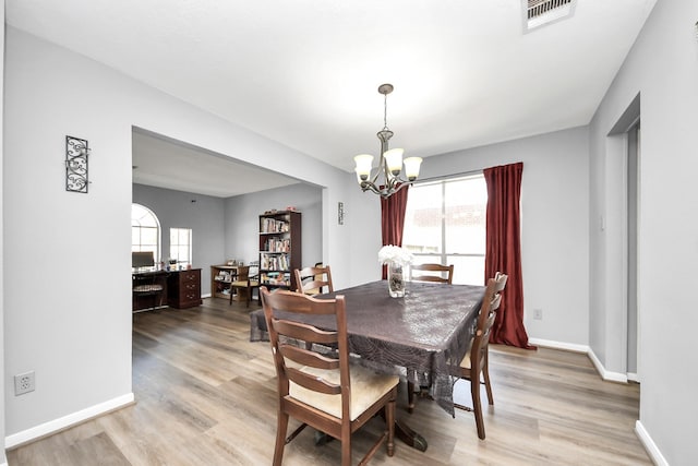 dining space with a wealth of natural light, a chandelier, visible vents, and light wood-style floors