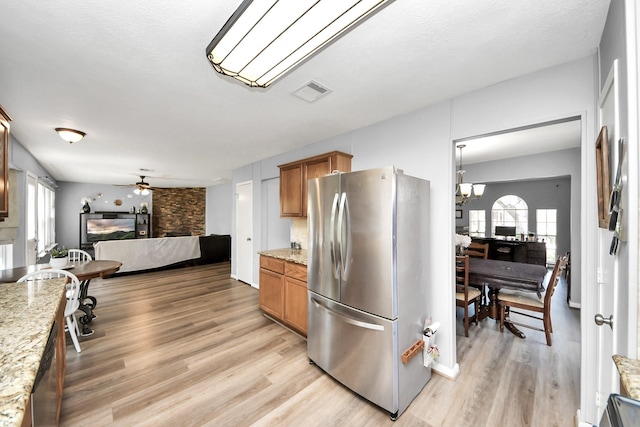kitchen featuring visible vents, plenty of natural light, freestanding refrigerator, and light wood finished floors