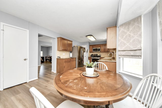 dining space with light wood-style floors and baseboards