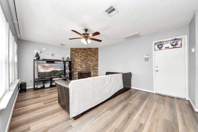 living room with wood finished floors, visible vents, and ceiling fan