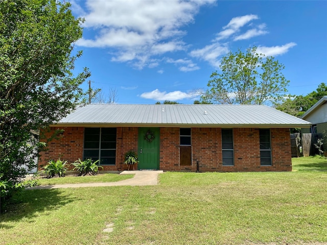 single story home featuring a front lawn, brick siding, and metal roof