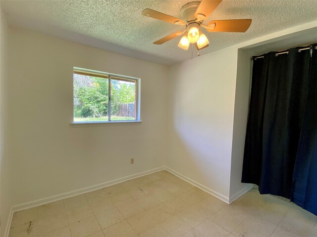 empty room with baseboards, a textured ceiling, and ceiling fan