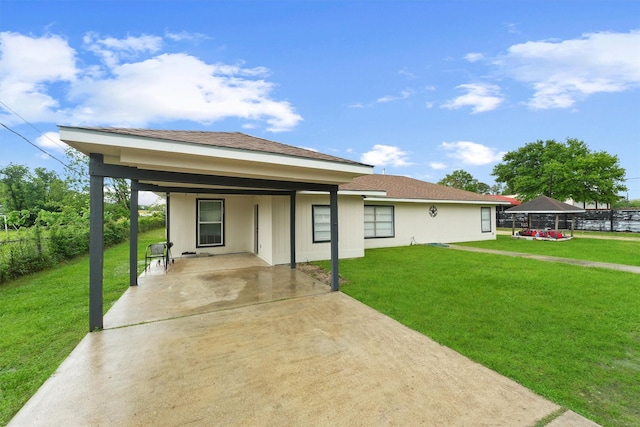 view of front of home featuring a front lawn, an attached carport, and concrete driveway