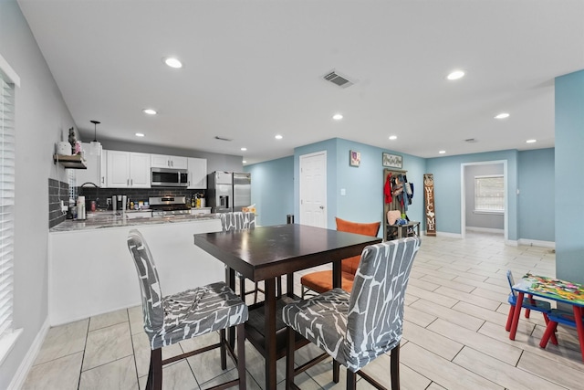 dining space with baseboards, visible vents, and recessed lighting