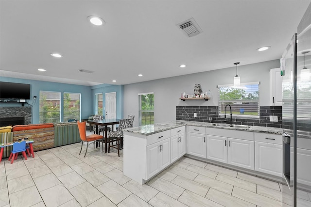 kitchen featuring plenty of natural light, visible vents, a sink, and backsplash