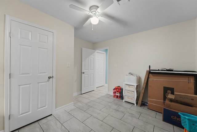 interior space with light tile patterned flooring, visible vents, baseboards, and ceiling fan