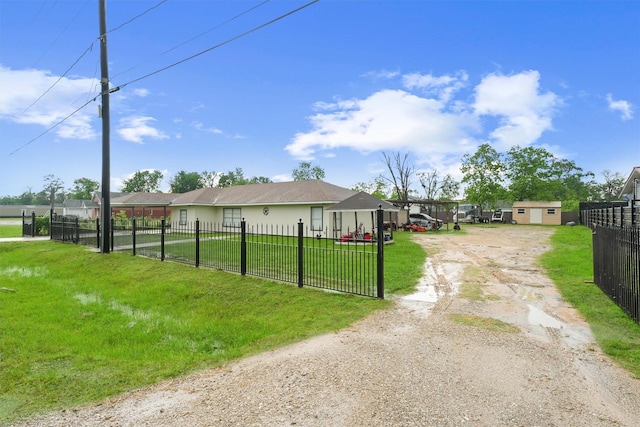 exterior space featuring fence private yard, dirt driveway, and a front yard