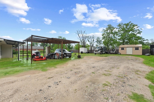view of car parking with a detached carport, dirt driveway, and a storage shed