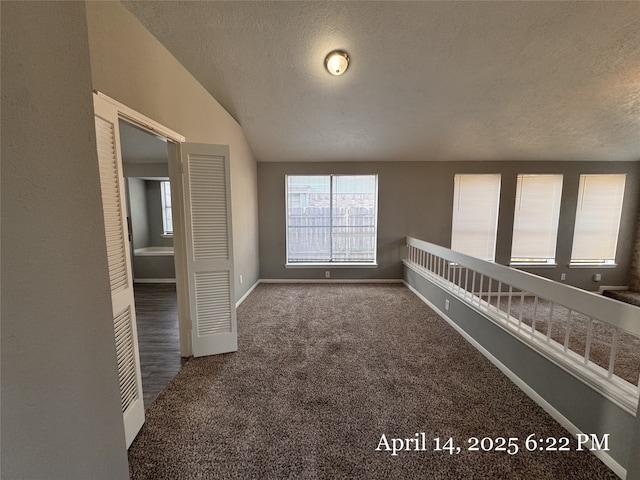 unfurnished room with a healthy amount of sunlight, carpet flooring, and a textured ceiling