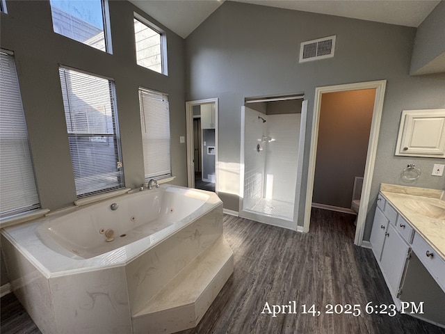 full bath with a stall shower, toilet, visible vents, wood finished floors, and vanity