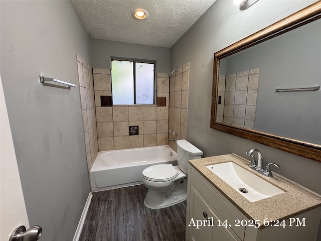 bathroom with wood finished floors, a textured ceiling, vanity,  shower combination, and toilet