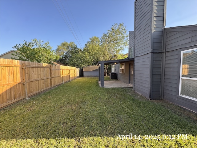 view of yard with a patio area, a fenced backyard, and central AC