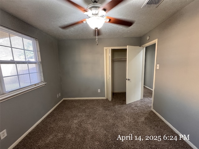 unfurnished bedroom featuring carpet flooring, a textured ceiling, visible vents, and a closet