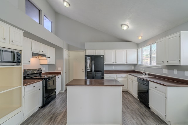 8810 Enchanted Forest Dr, Houston, TX 77088 - kitchen featuring under cabinet range hood, white cabinetry, black appliances, and a center island