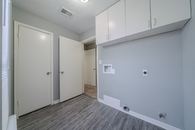 8810 Enchanted Forest Dr, Houston, TX 77088 - washroom with washer hookup, hookup for an electric dryer, visible vents, cabinet space, and wood finished floors