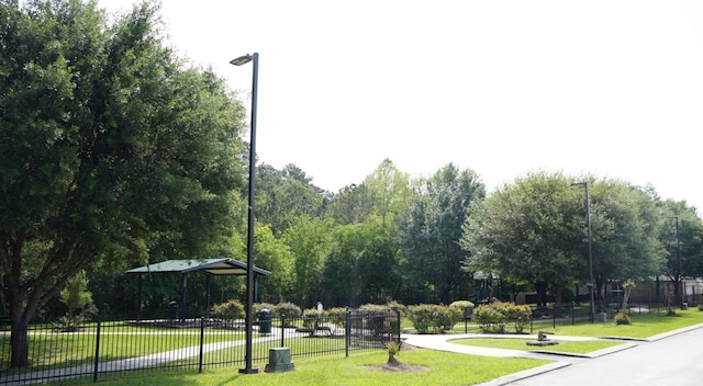 surrounding community with a lawn and fence