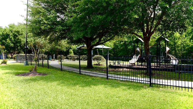 exterior space with a yard, fence, and playground community