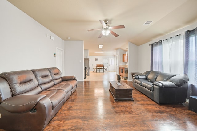 living room with wood finished floors, visible vents, baseboards, and ceiling fan