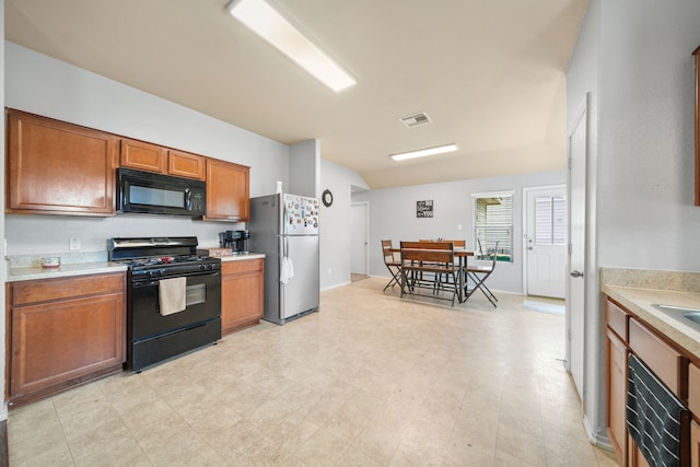 kitchen with light countertops, visible vents, brown cabinets, and black appliances