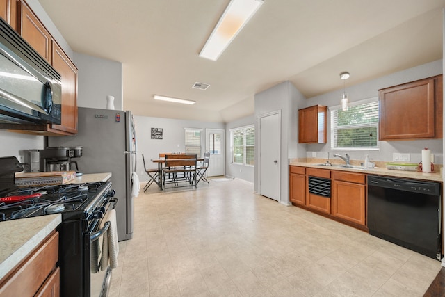 kitchen with light countertops, a sink, brown cabinets, and black appliances