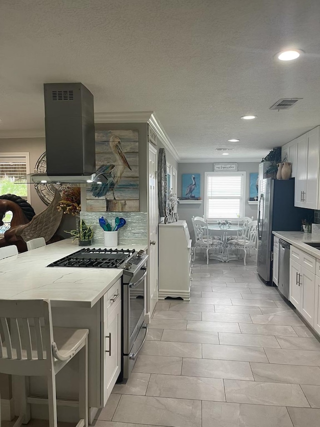 kitchen featuring stainless steel appliances, decorative backsplash, white cabinets, recessed lighting, and ornamental molding