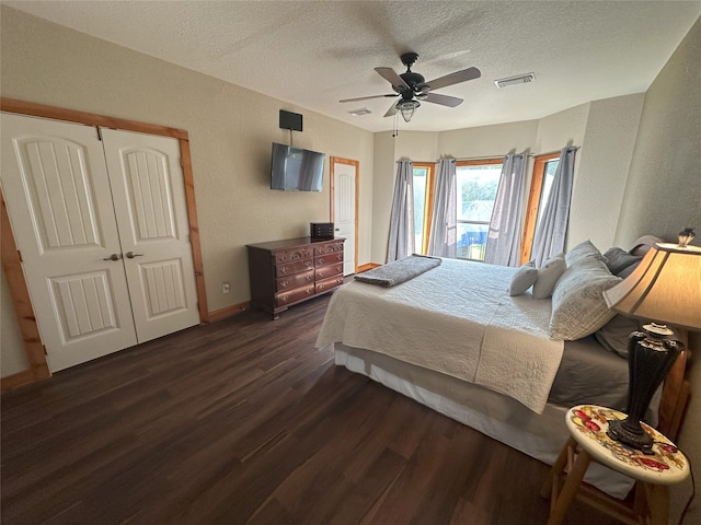 15395 Kitty Hawk Dr, Waller, TX 77484 - bedroom featuring dark wood-style floors, a textured ceiling, visible vents, baseboards, and a textured wall