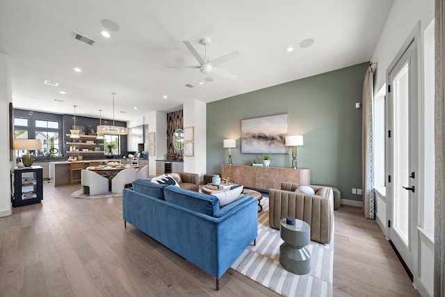 living area with recessed lighting, a ceiling fan, visible vents, and wood finished floors