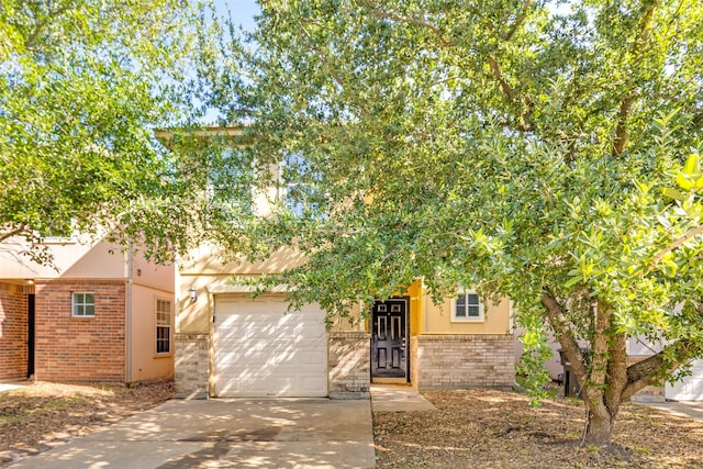4934 S Cancun Dr, Houston, TX 77045 - view of front of house with an attached garage, driveway, brick siding, and stucco siding