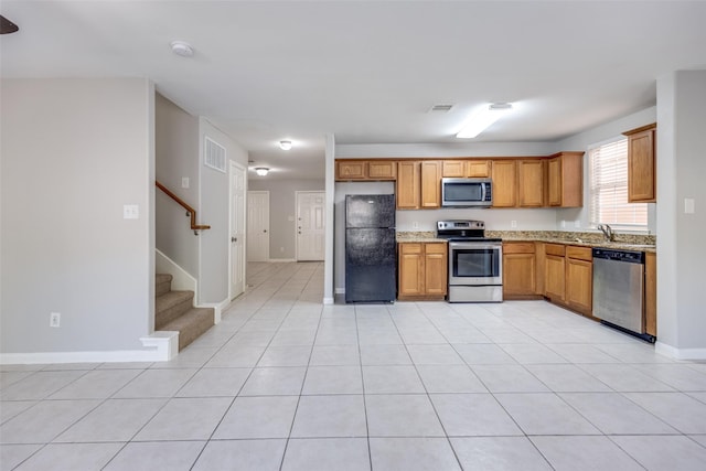 4934 S Cancun Dr, Houston, TX 77045 - kitchen with light stone countertops, visible vents, appliances with stainless steel finishes, and a sink