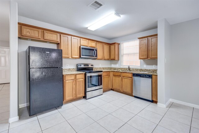 4934 S Cancun Dr, Houston, TX 77045 - kitchen featuring a sink, baseboards, appliances with stainless steel finishes, light stone countertops, and visible vents