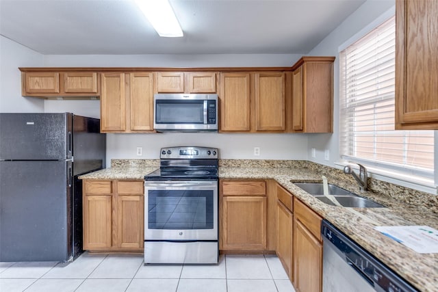 4934 S Cancun Dr, Houston, TX 77045 - kitchen with plenty of natural light, light tile patterned floors, stainless steel appliances, and a sink