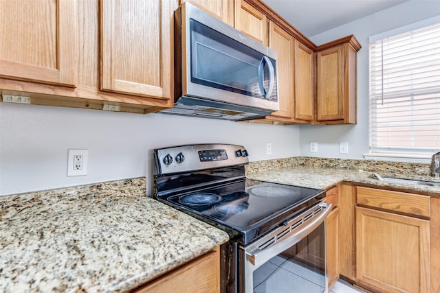 4934 S Cancun Dr, Houston, TX 77045 - kitchen with light stone countertops, a wealth of natural light, stainless steel appliances, and a sink