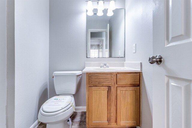 4934 S Cancun Dr, Houston, TX 77045 - bathroom featuring toilet, baseboards, a notable chandelier, tile patterned flooring, and vanity