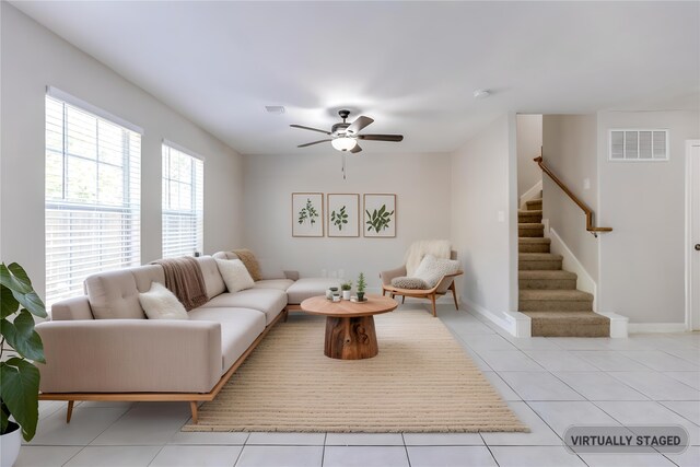 4934 S Cancun Dr, Houston, TX 77045 - living room with stairway, light tile patterned floors, ceiling fan, baseboards, and visible vents