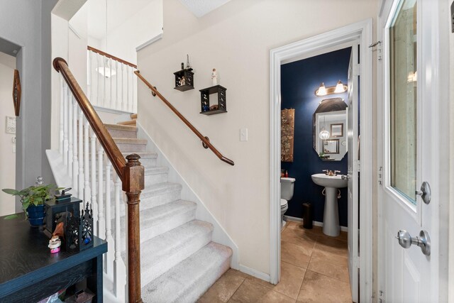 stairs with baseboards and tile patterned floors