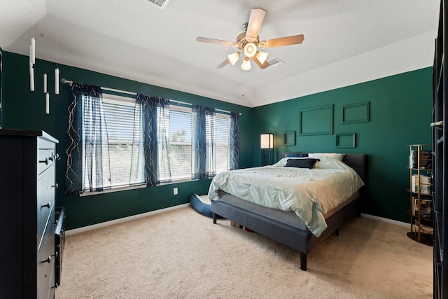 carpeted bedroom with visible vents, a ceiling fan, and baseboards