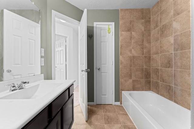 full bathroom featuring tile patterned flooring, vanity, and a textured ceiling