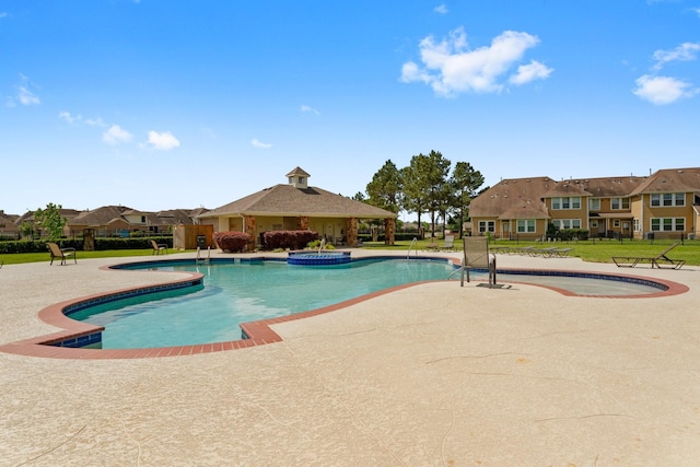 view of pool featuring a residential view, a gazebo, a patio area, a yard, and a pool with connected hot tub