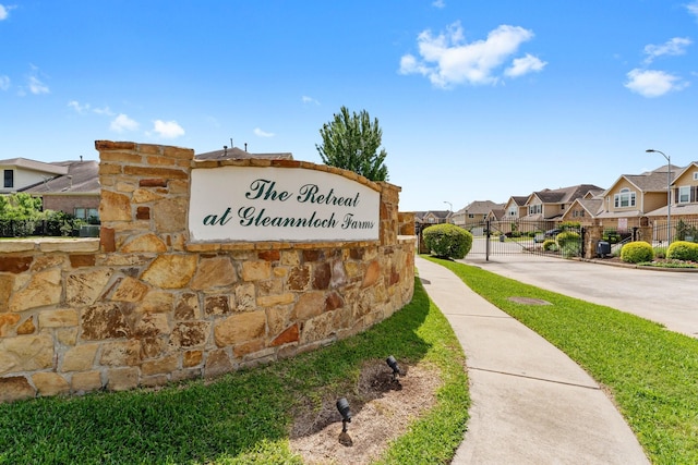 community sign with a gate, a residential view, and fence
