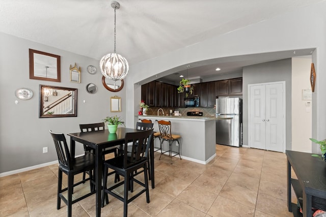 dining space featuring recessed lighting, light tile patterned floors, arched walkways, baseboards, and a chandelier