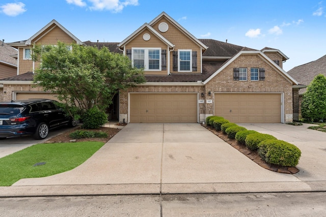 townhome / multi-family property with an attached garage, a shingled roof, brick siding, and concrete driveway