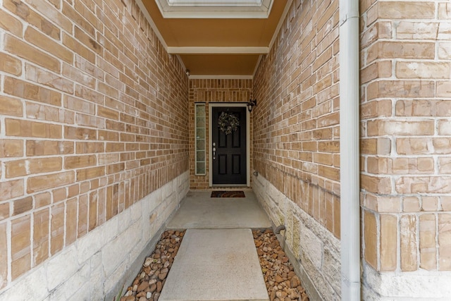 entrance to property featuring brick siding