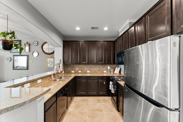 kitchen featuring visible vents, a sink, light stone countertops, dark brown cabinetry, and black appliances