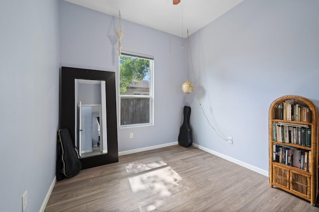 unfurnished room with wood finished floors, baseboards, and ceiling fan