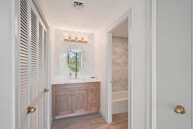 661 Bering Dr Unit 301, Houston, TX 77057 - full bathroom featuring vanity, wood finished floors, a closet, and  shower combination